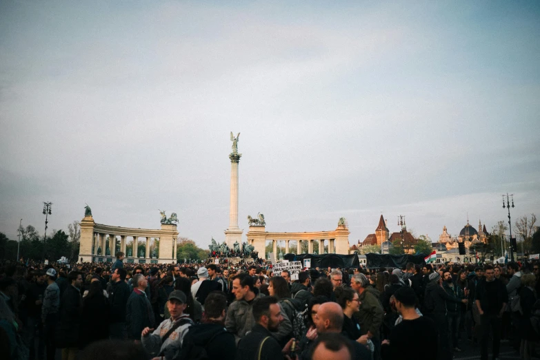 large group of people standing next to a tall building