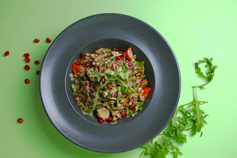 a green bowl filled with meat and vegetables