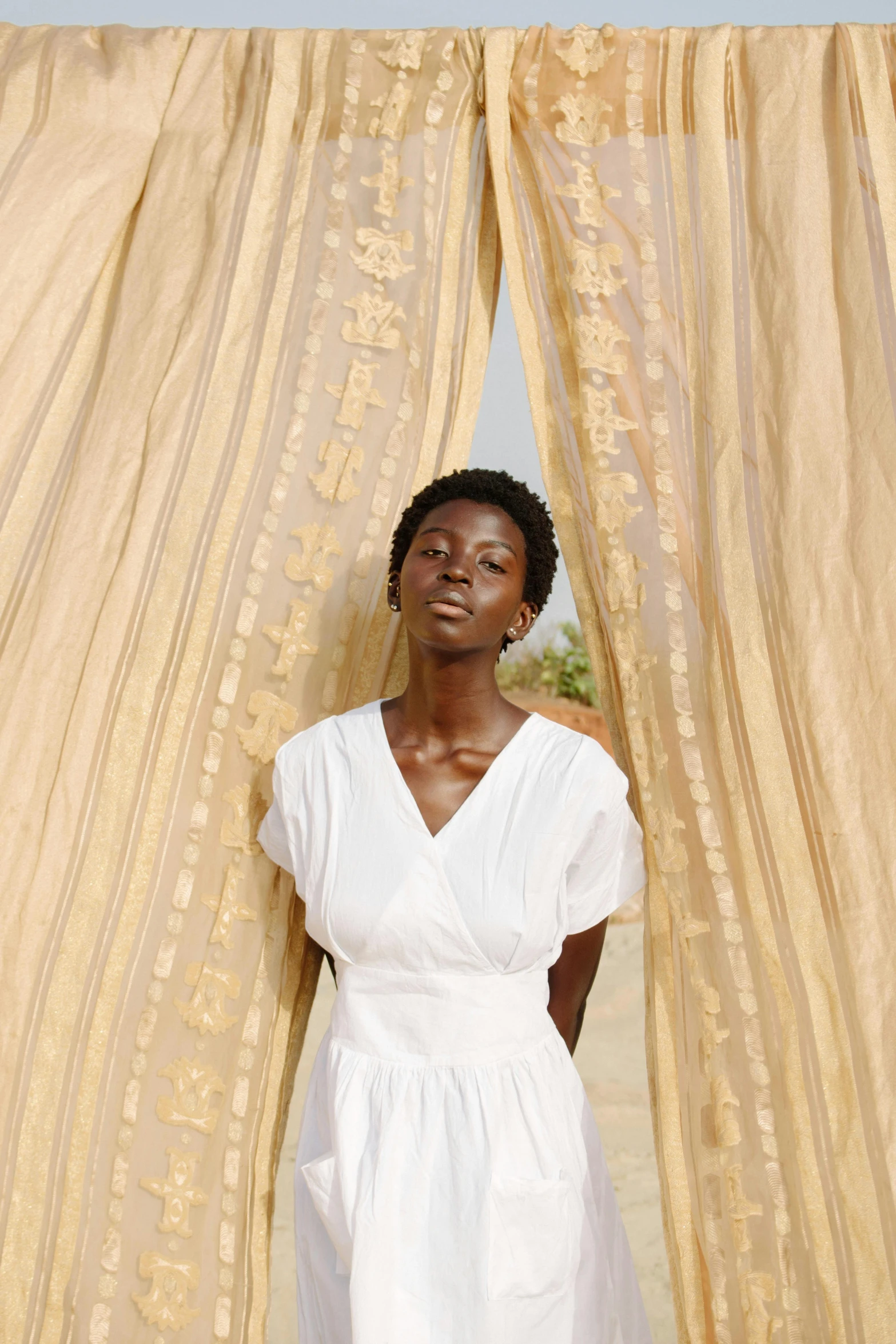 a woman standing in front of a window with curtains