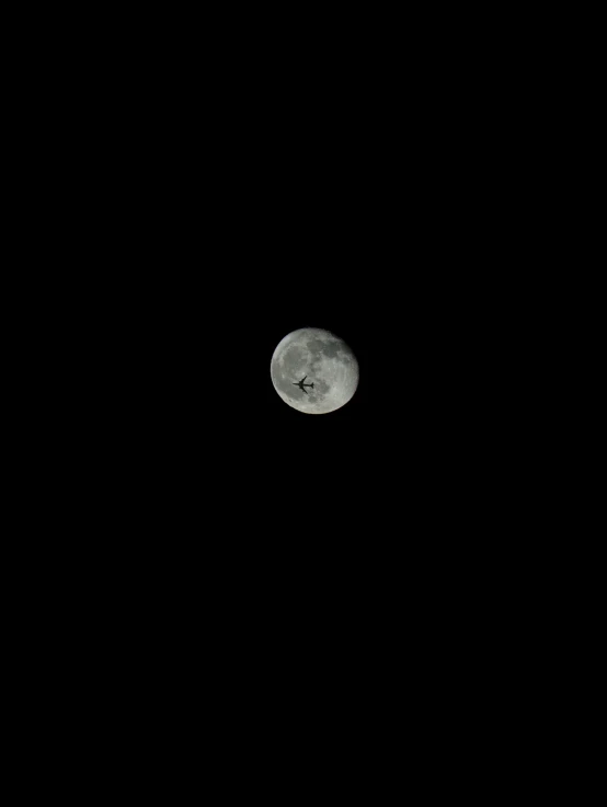 the moon is above the black surface with no clouds