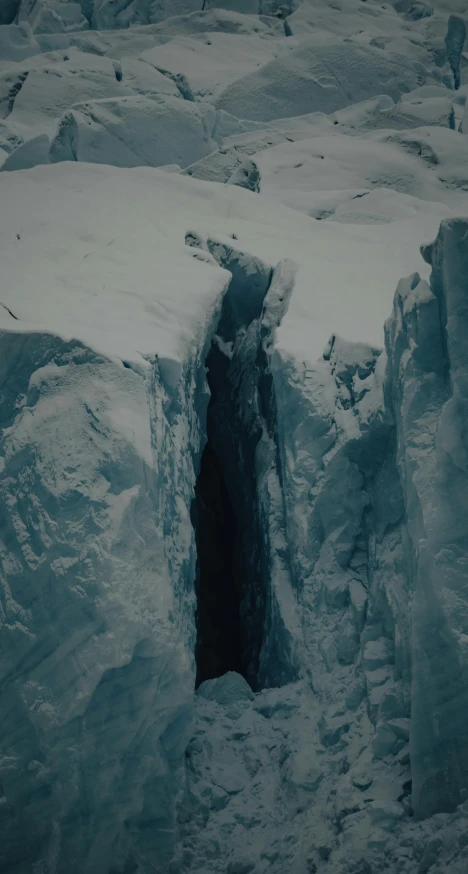 an ice cave is filled with snow, surrounded by thick blue ice