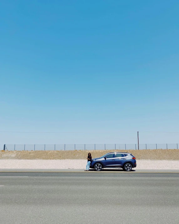 the small blue vehicle is parked in the middle of the road