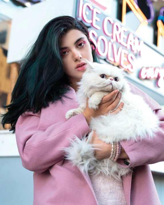 a close up of a person holding a small cat