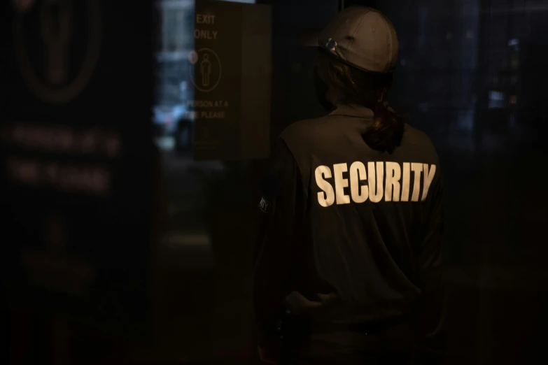 a security officer standing in the dark near a sign