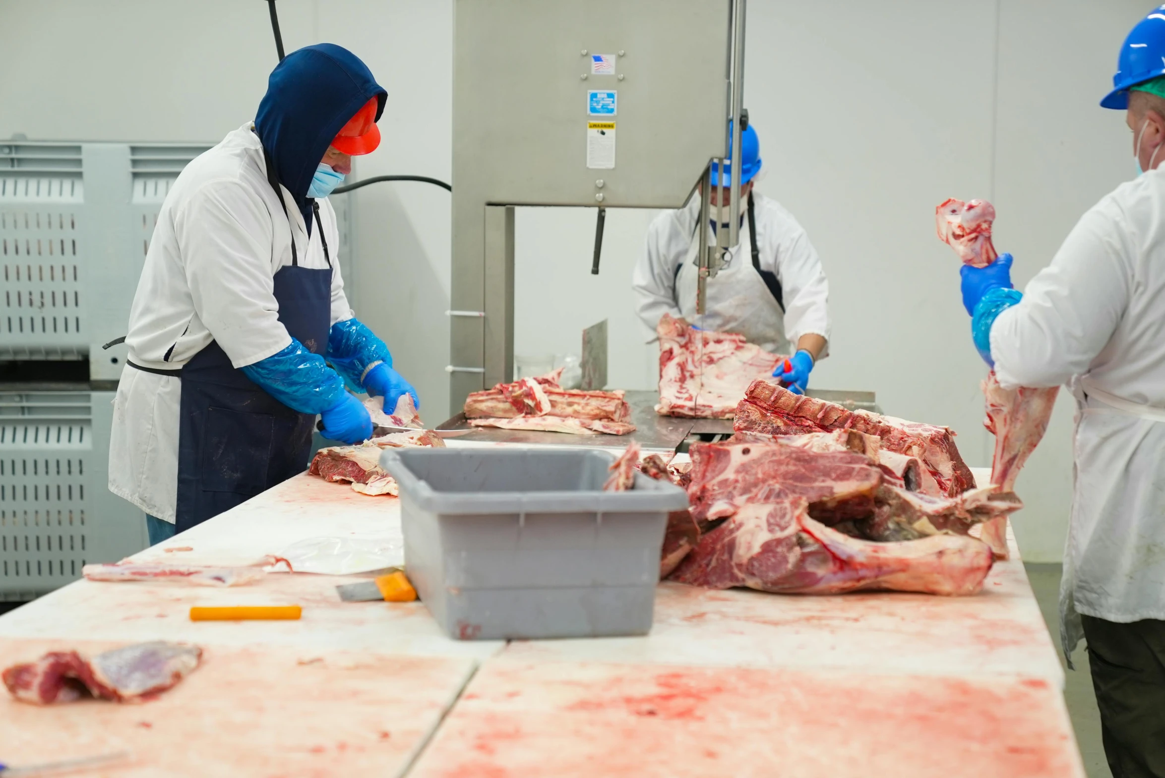 several workers working in a butcher shop