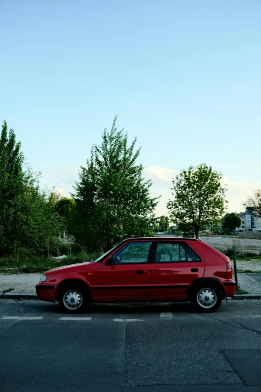 a small red car parked in a parking lot