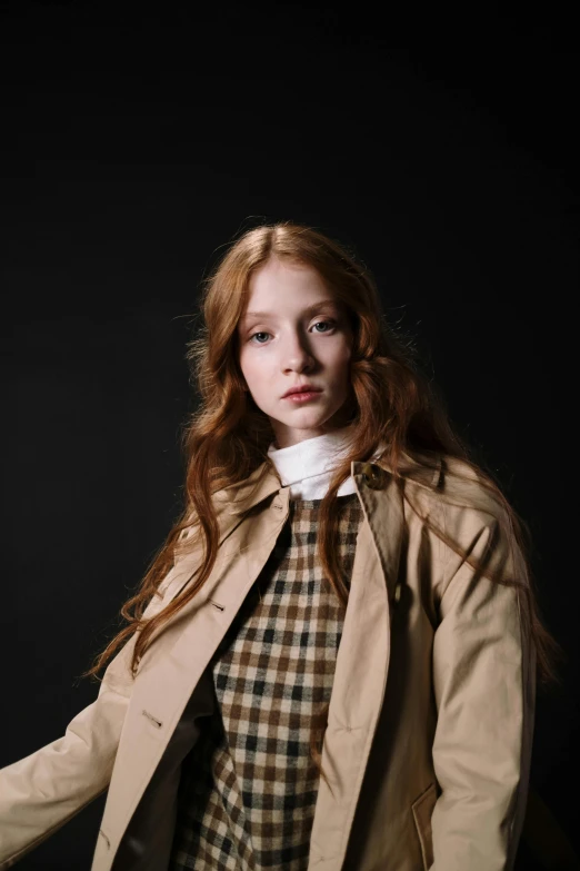 young redhead girl with blue eyes, brown hair wearing coat and checkered shirt and black background