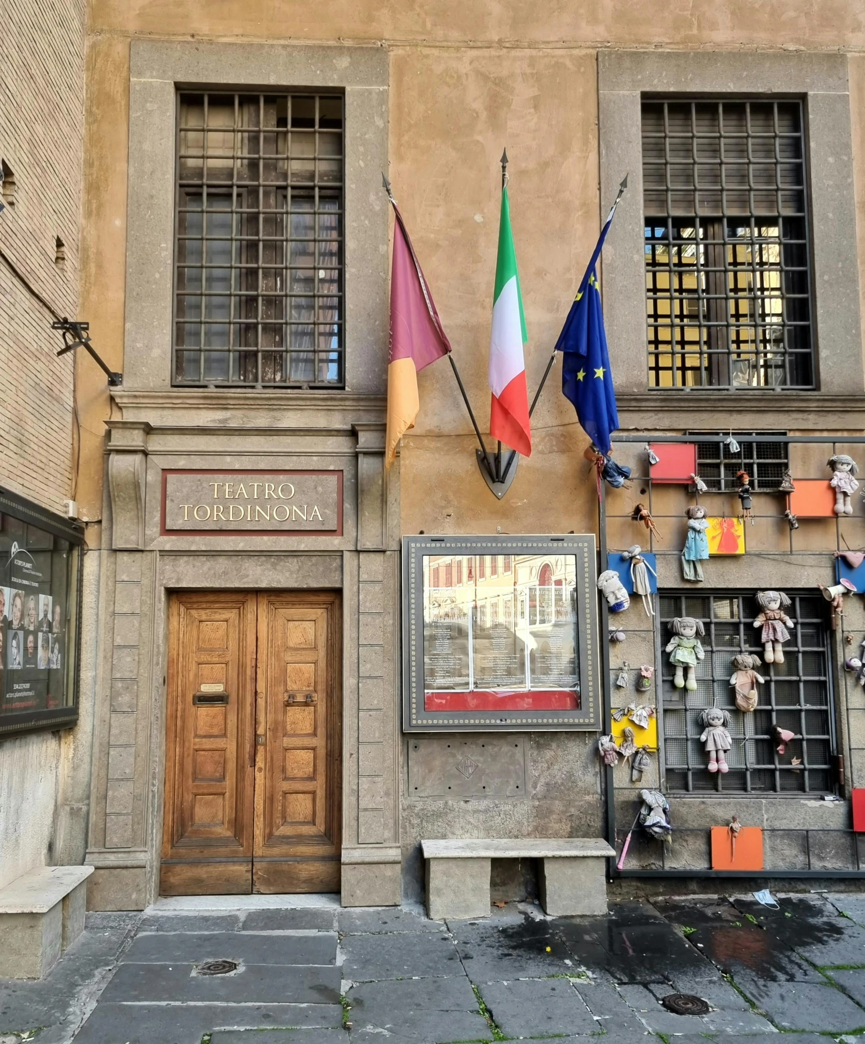 flags and posters in the windows of this small old building