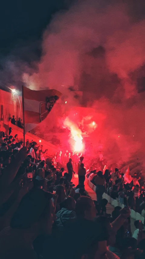 a crowd watching a huge fireworks show with lights on