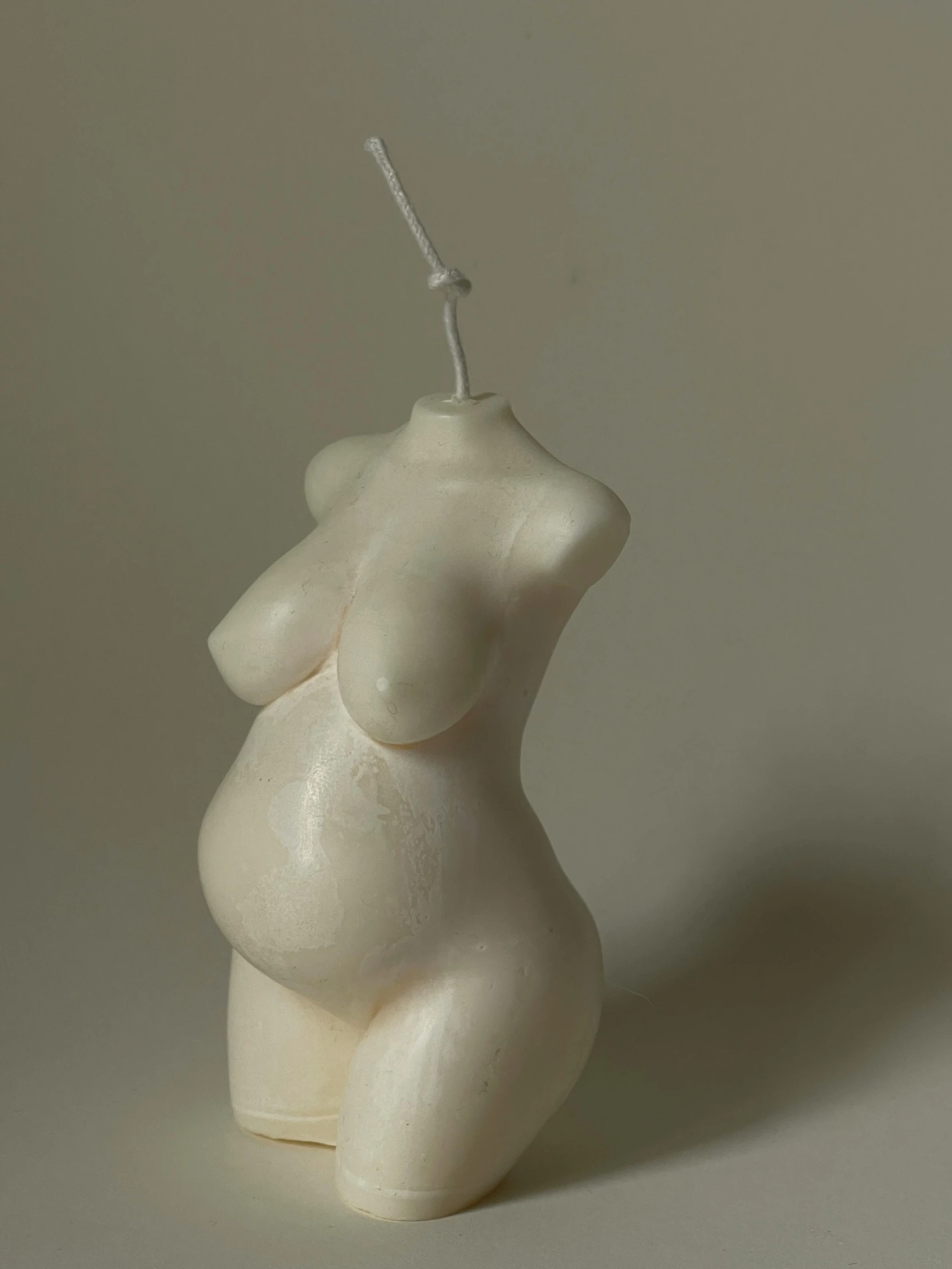 a white plastic figure is hanging from a stick
