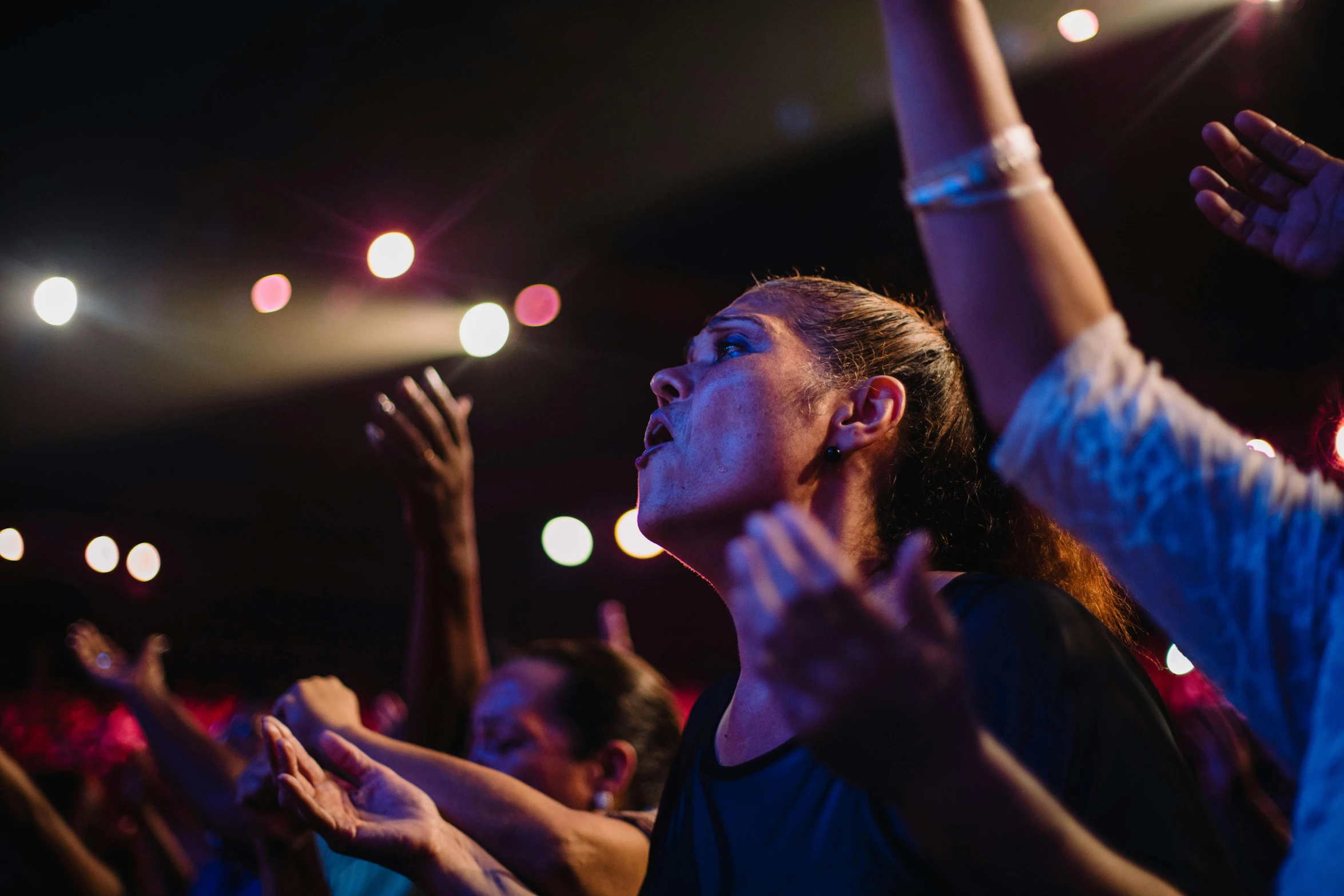 people clapping in a darkened place at night