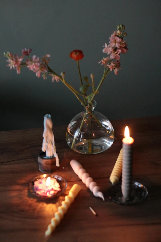 a candle, some cookies and flowers in a vase