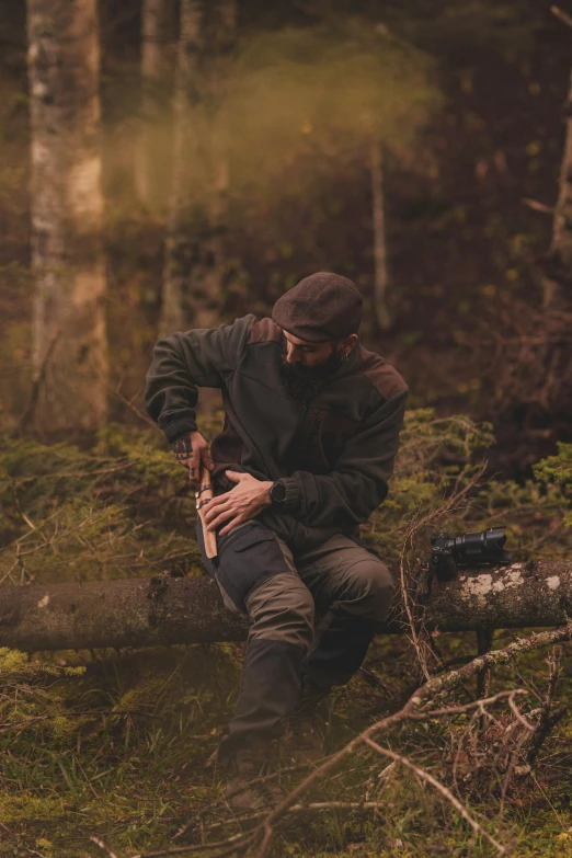 a man kneeling on the ground in front of trees