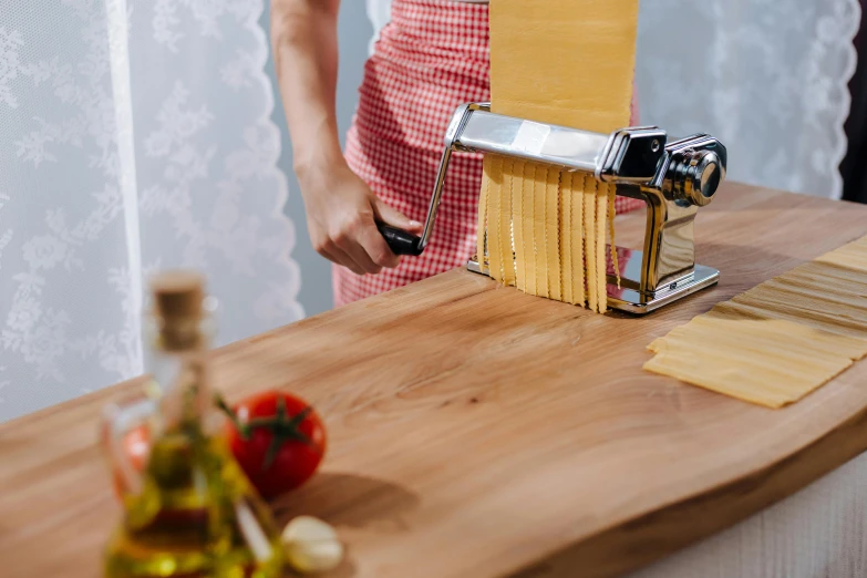 a person standing over a table next to a wooden board with a knife and paint roller