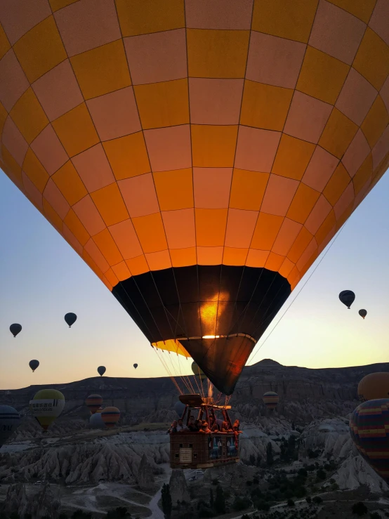 a sky full of balloons flying over a land