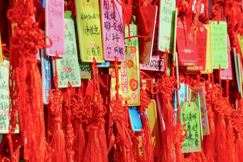 bright red paper signs with chinese writing are hung from a pole