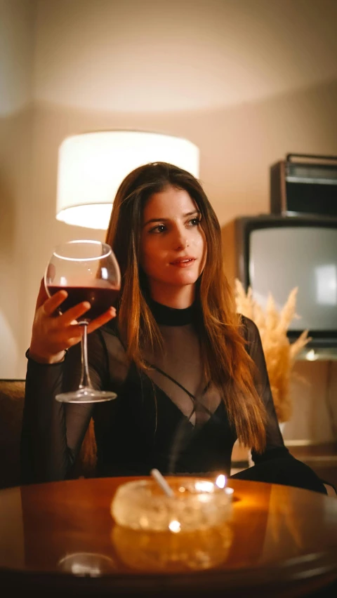 a woman at a table with a glass of wine