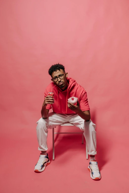 a man sitting on a chair and holding a drink