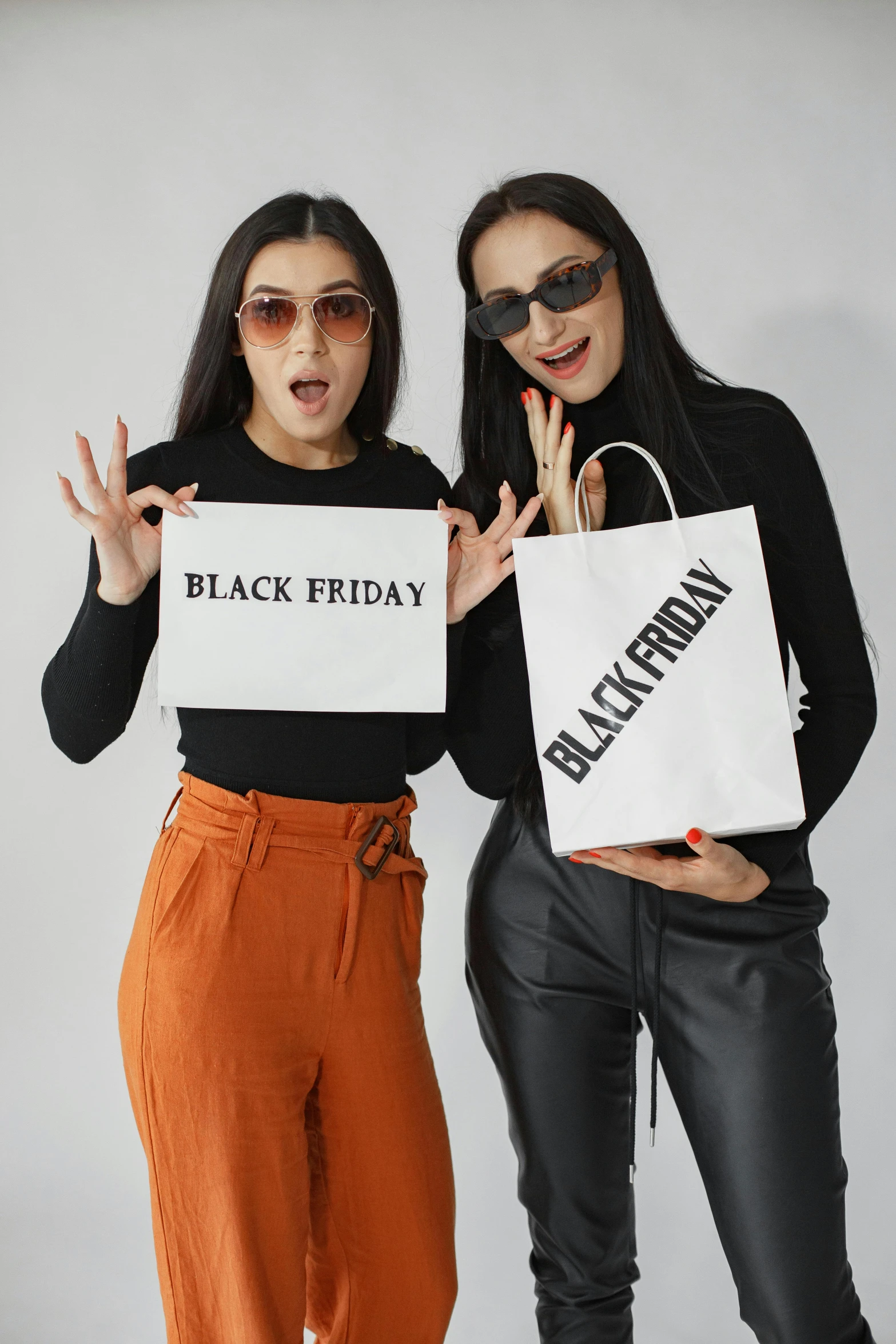 two women with black friday shopping bags in their hands