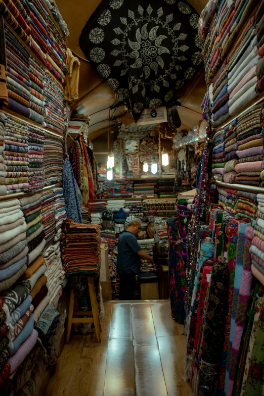 an old man shopping in a store with lots of cloth