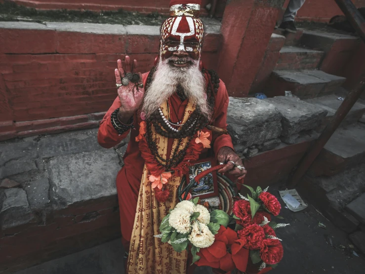 a man wearing a fancy costume is holding a bouquet