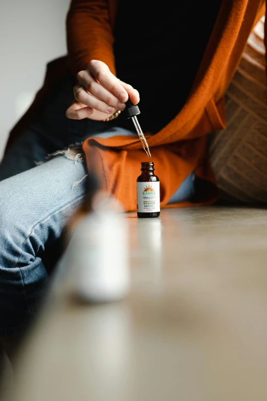 a person is sitting down and holding their cap of soing