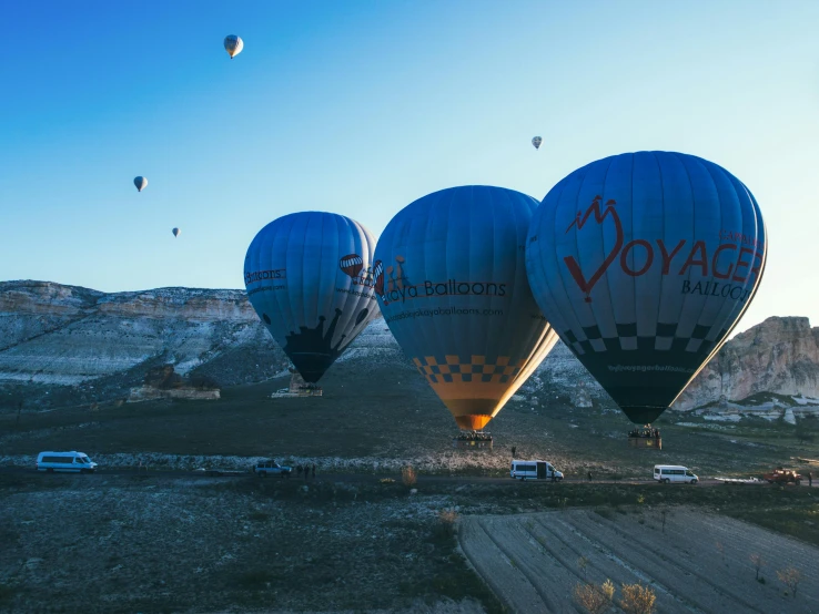 the large air balloons are flying high up in the sky