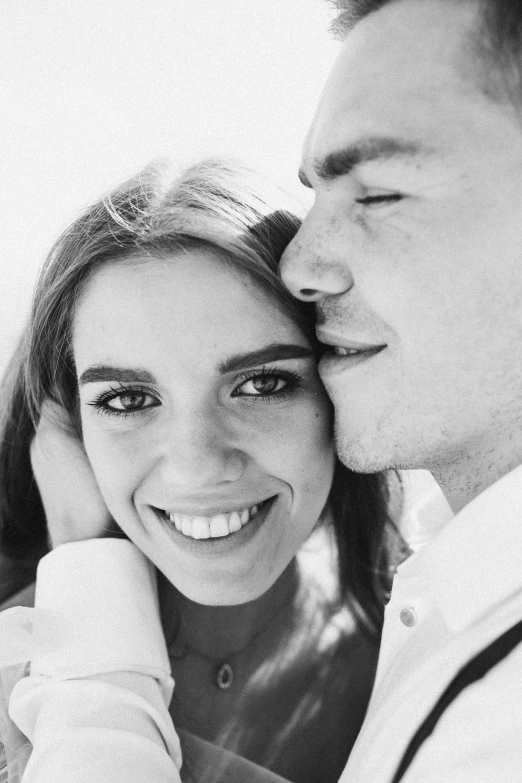 a young couple kissing next to each other