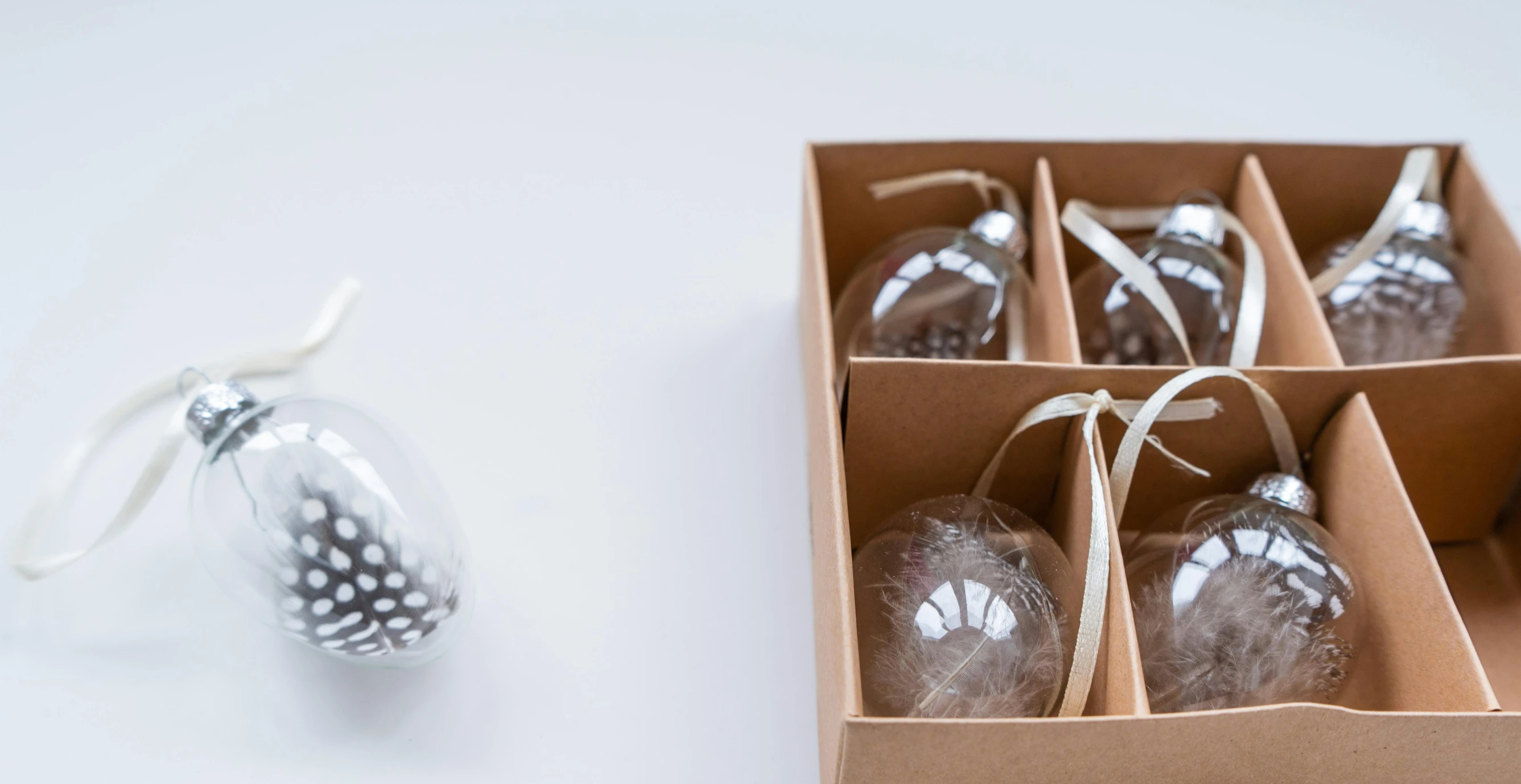 an opened box of glass ornaments sitting next to an ornament