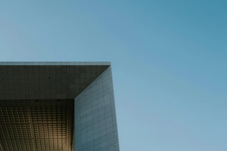 the side of a building with a very tall bird sitting on it's roof