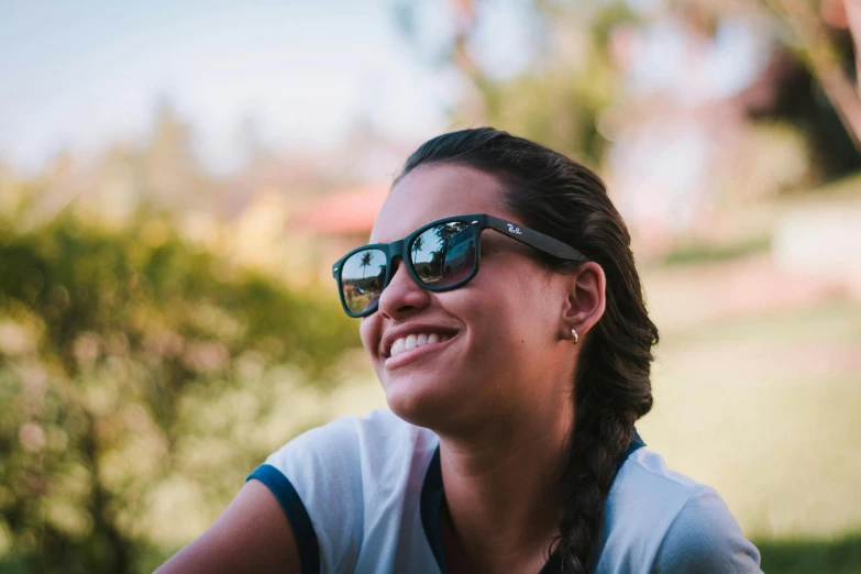 a woman in sunglasses with her hair in a pony tail id