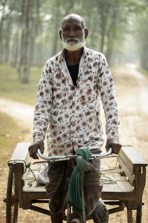 an old man rides a bicycle with two people on it