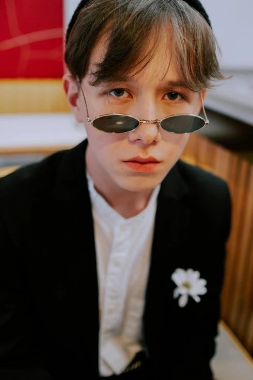 young man wearing glasses with the shape of a flower in front of him