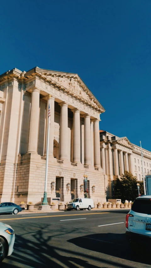 a building that has two large pillars next to a street