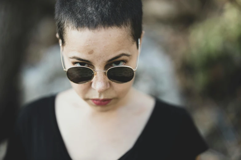 a woman wearing sunglasses on a dark background