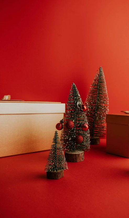 four plastic christmas trees with ornaments in their stands