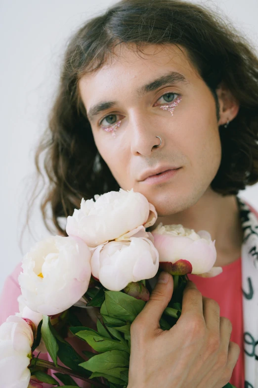 a man holding a bunch of flowers to his lips