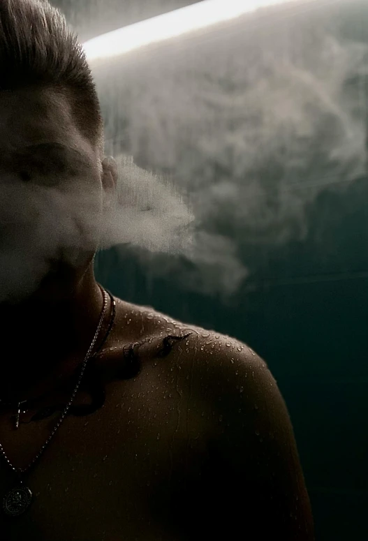 the man looks like he is smoking in a smoke machine