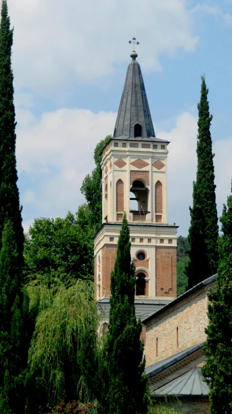 a tall clock tower behind some trees