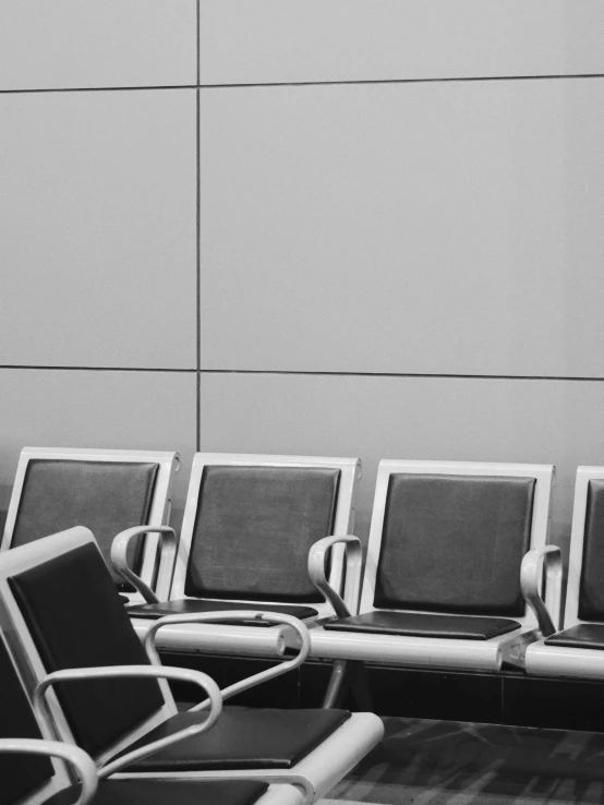 chairs and railings line up in front of a wall