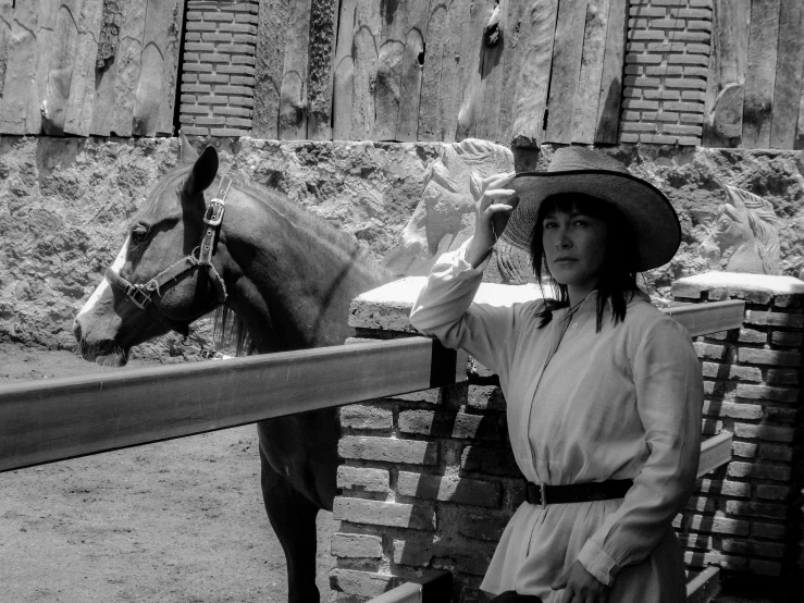 a black and white po of a woman holding the hand of a horse