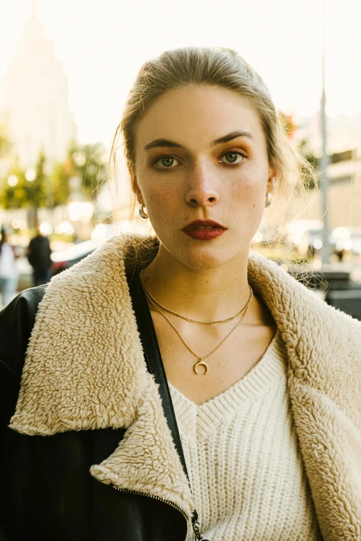 a beautiful young lady with a black jacket and a yellow necklace