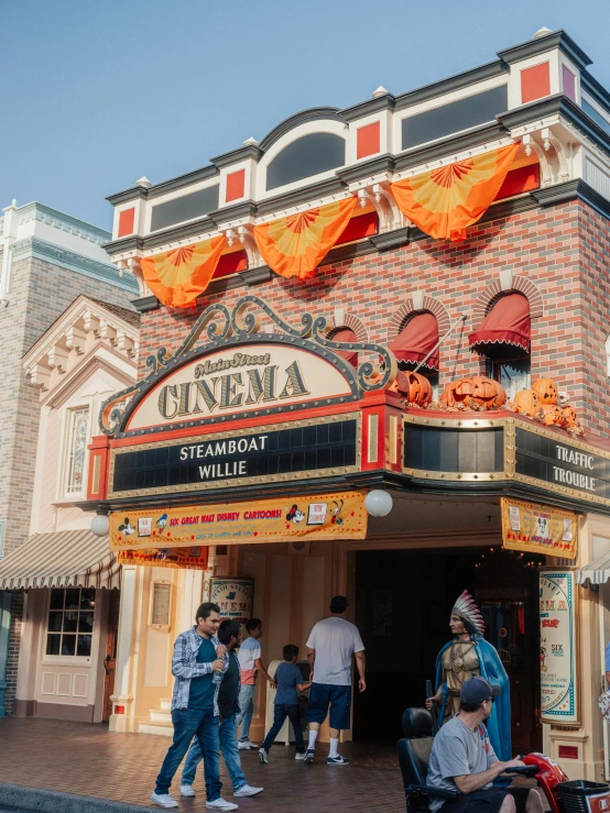 people are walking in front of a theater building