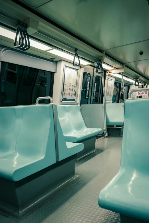 the inside of a train that has blue chairs on it