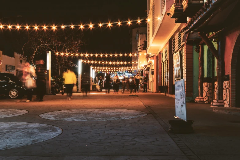 this po has people walking down the sidewalk at night