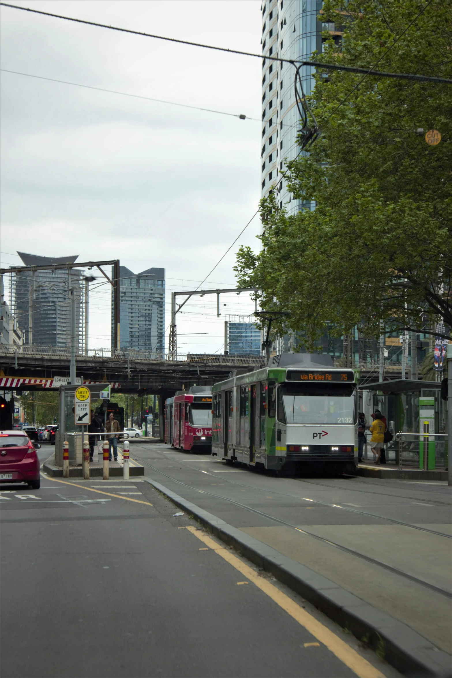 a city street is shown with people waiting for their train