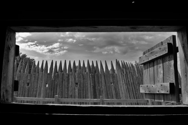 a black and white pograph of wooden fences