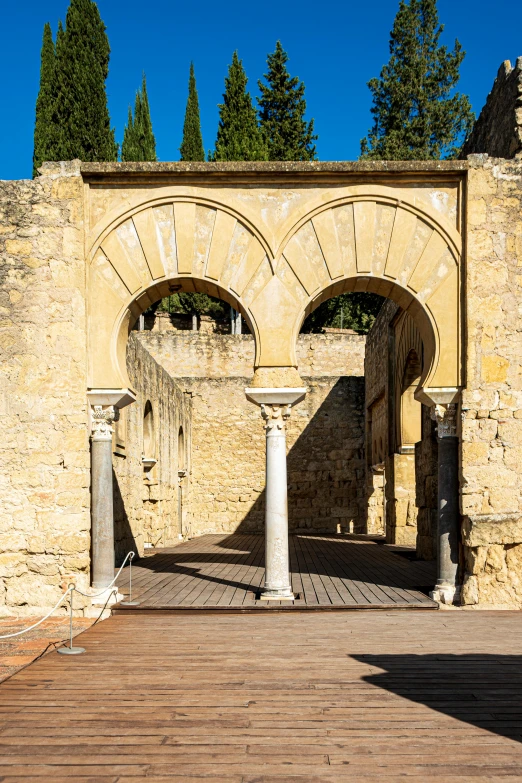 a doorway with arched doors sits in front of a wooden floor