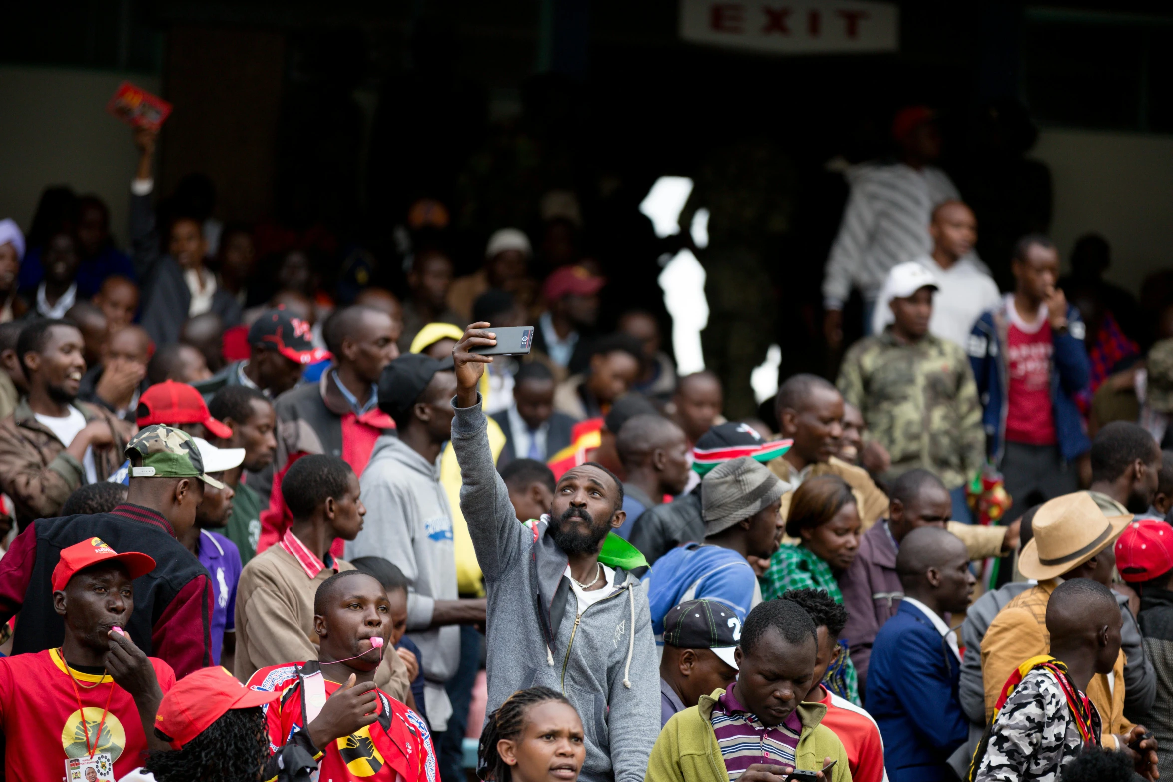 a crowd watching people using phones in an audience