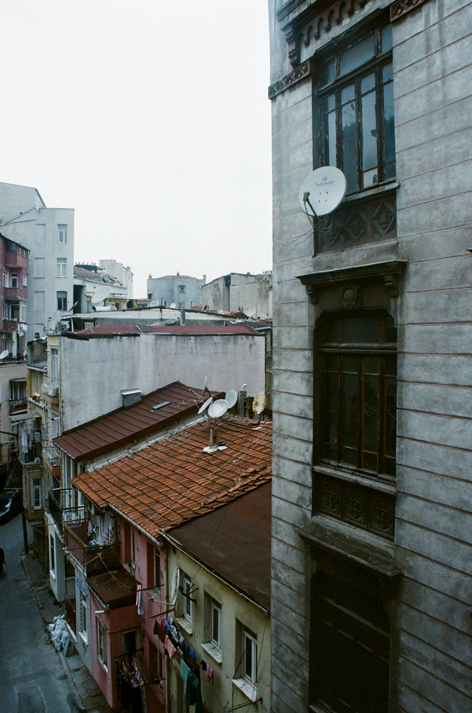 an old, weathered building with many windows and a weather vane on top of the roof